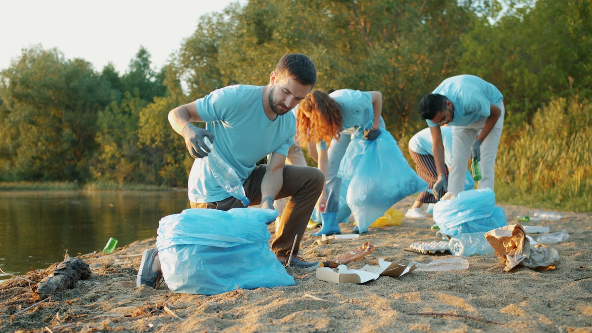 Volunteers collecting litter along a riverbank