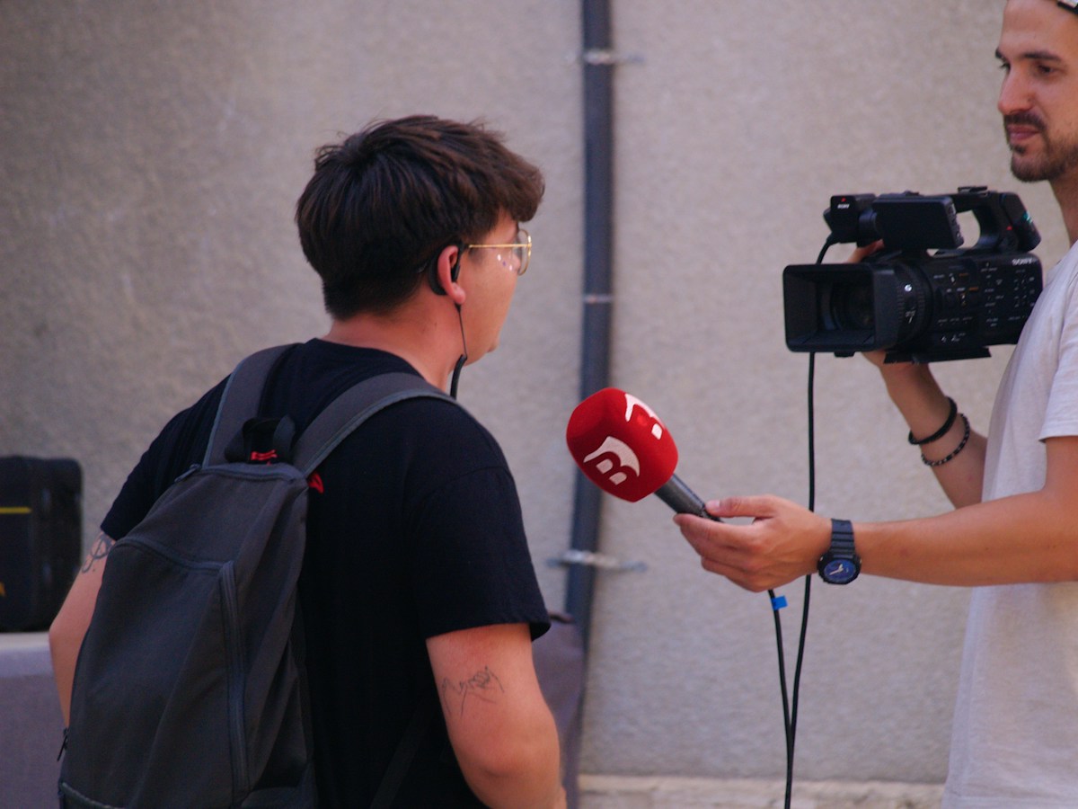 A street interview with a microphone and video camera