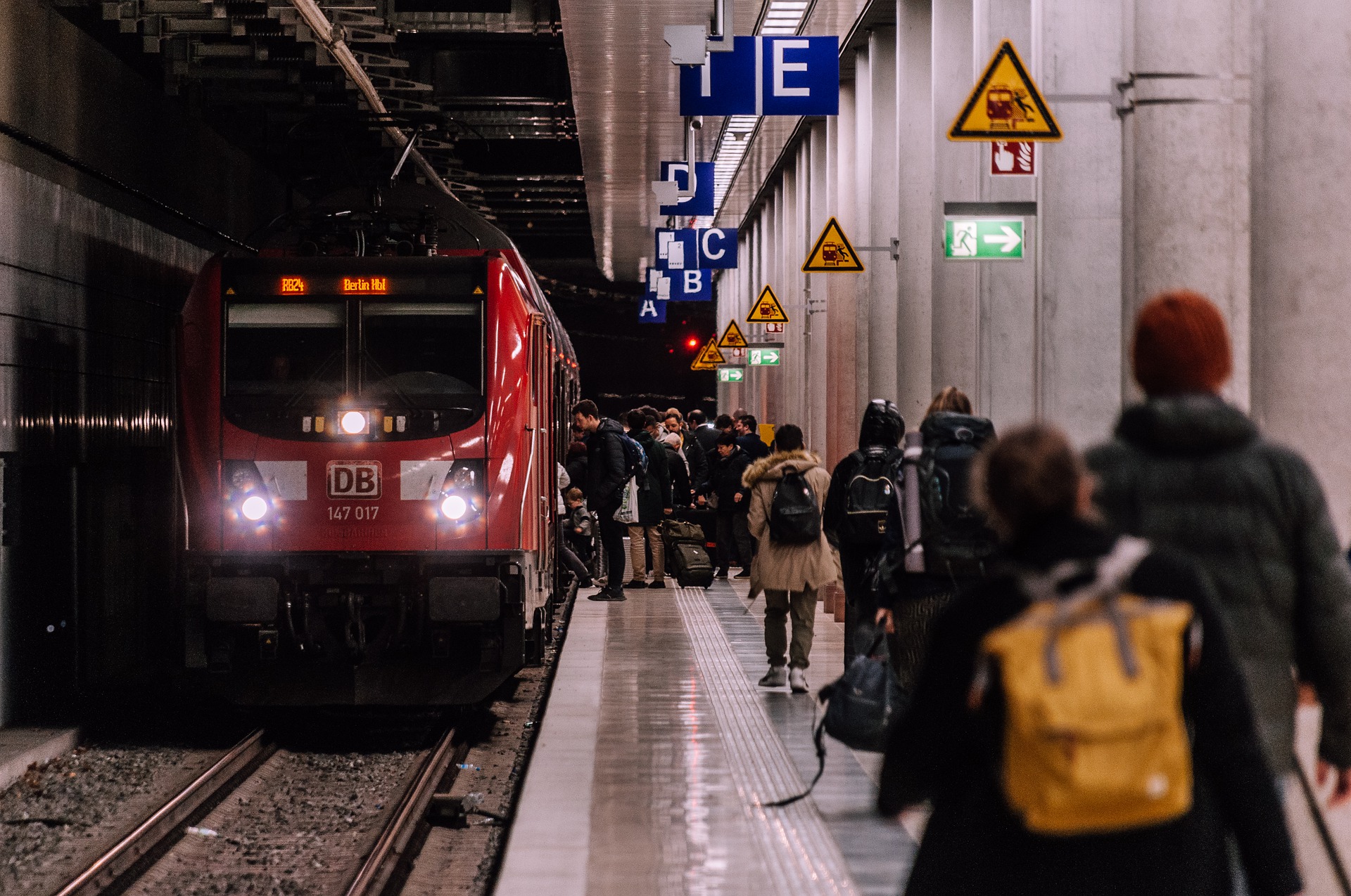 Train to Berlin at a station, passengers walking in. An image of sustainable mobility solution.