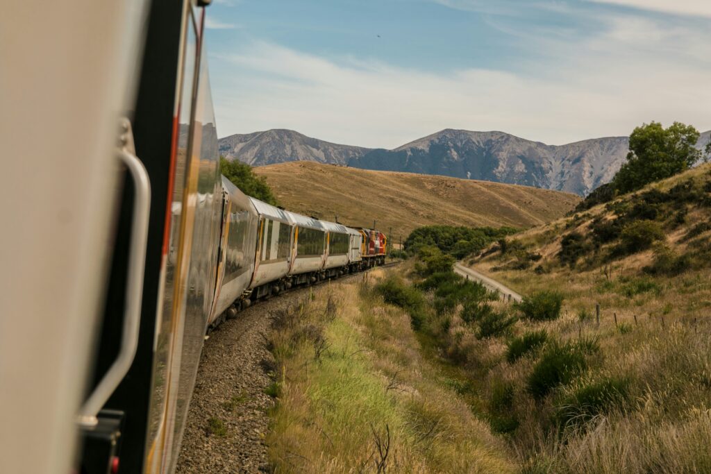 Train passing through a mountain range. Sustainable mobility paired with wild nature.